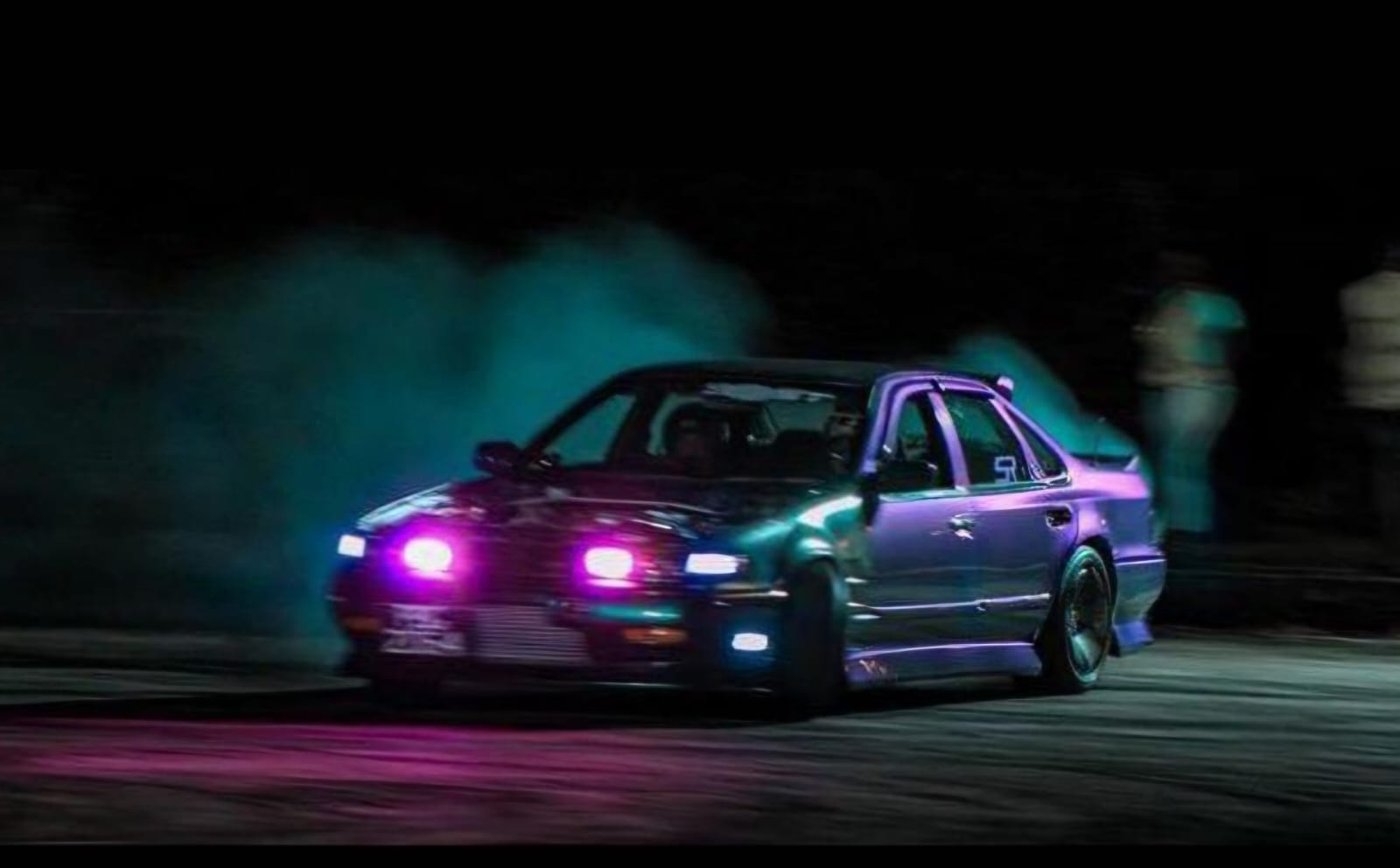 Purple sedan at night with glowing pink headlights and blue fog lights